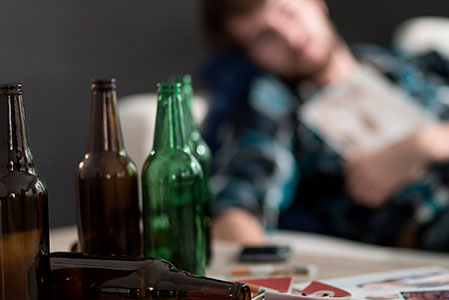 Пьяный мужчина и пустые бутылки